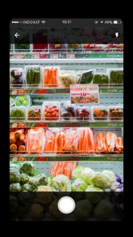 Retailer photographing an in-store product display for a campaign